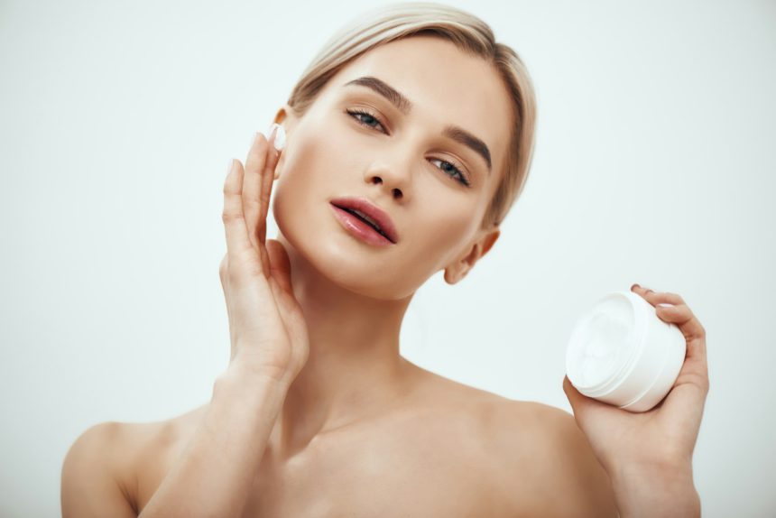 Best moisturizer for your skin type. Portrait of gorgeous young woman spreading cream on her face