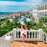 Girl in hat looking on sea in luxury resort