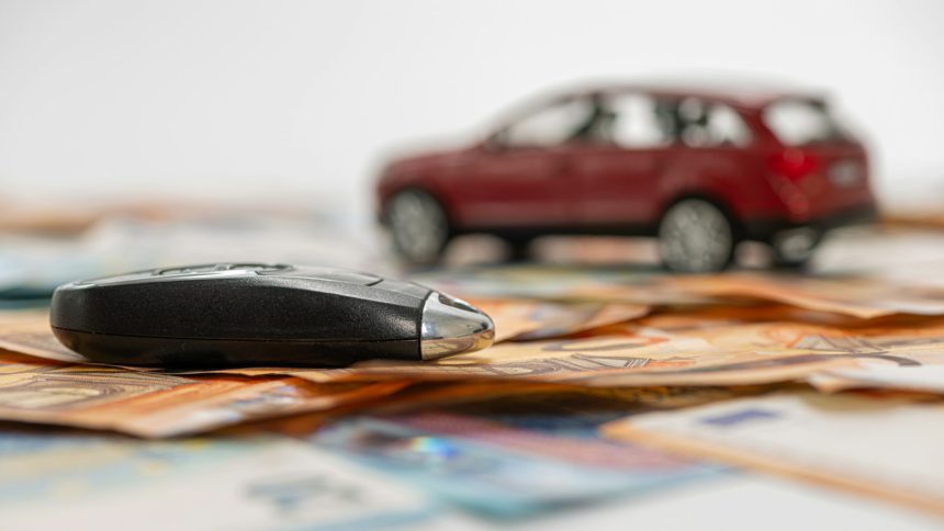 key and red toy car on pile of euro banknotes, buy or sell a car, rent a car or insurance concept