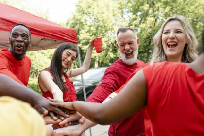 Sports fans in a huddle at a tailgate event